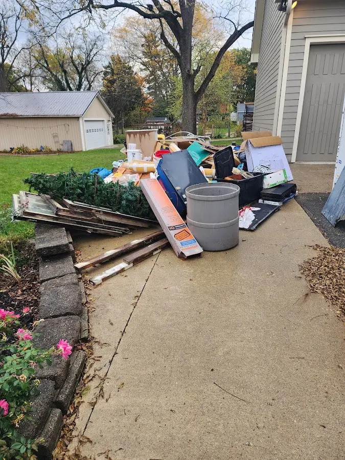 Dumpster being loaded with debris for Roofing Dumpster Rental in Grand Haven